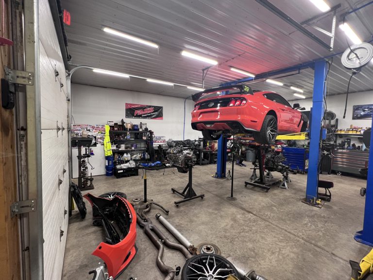 Service bays with a red Mustang on the lift