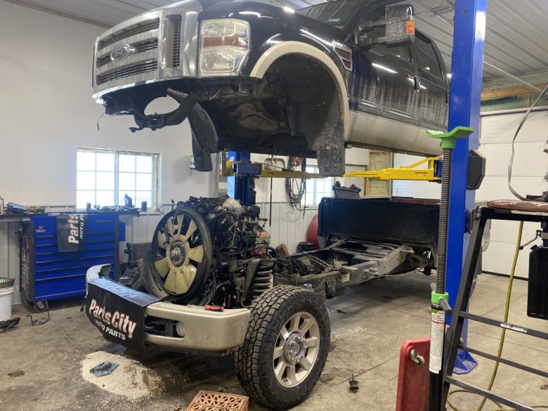 Remanufactured Diesel Engine vs. Rebuilt vs. Used: 7 Questions to Ask Before You Buy 3 Diesel truck on the lift with the engine removed for a remanufactured diesel engine replacement in Hammond, WI